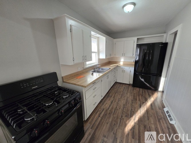 A kitchen with a black stove top oven and white cabinets.