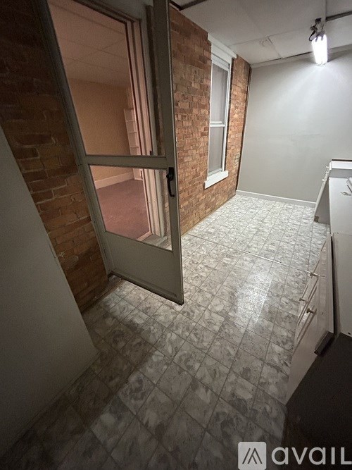 A room with a brick wall and a tiled floor.