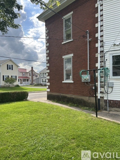 A brick house with a green lawn in front.