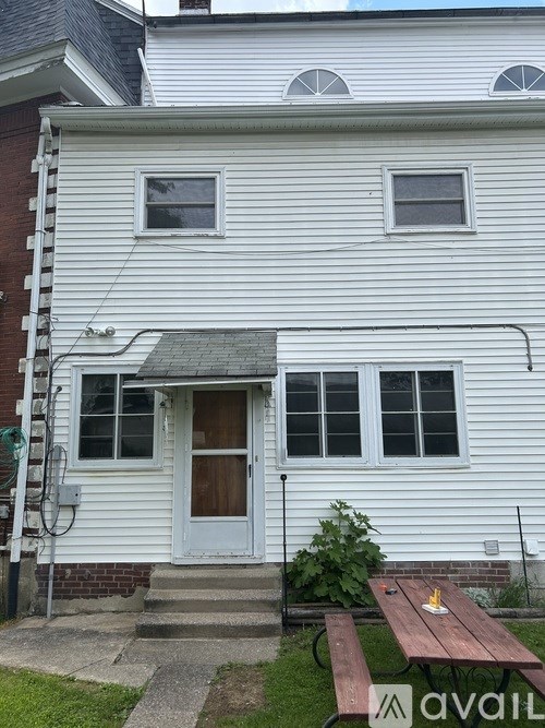A white house with a grey roof and a grey door.