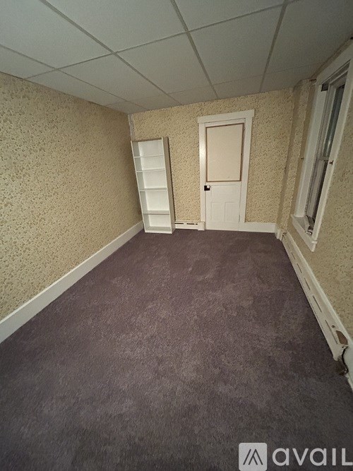 A room with wooden floors and a brick wall.