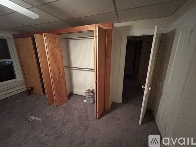 A room with a white door and a grey carpet.