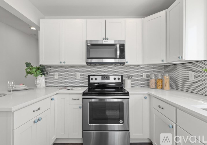 A kitchen with white cabinets and a stainless steel oven.