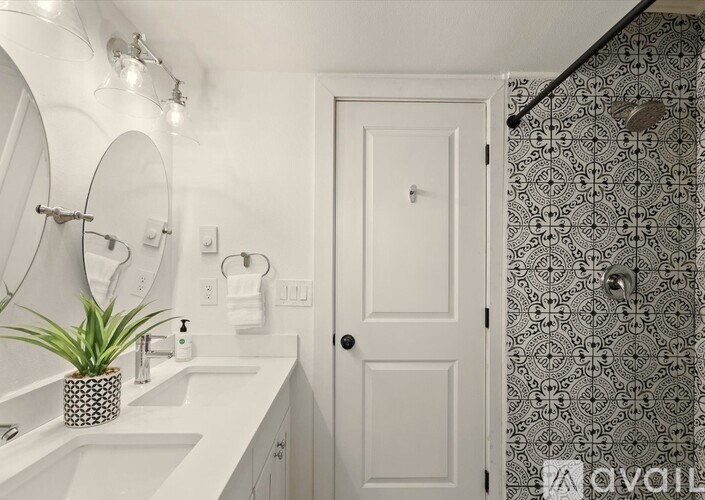 A bathroom with a white sink and a white door.