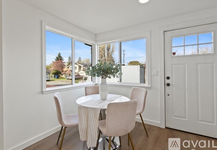 A dining room with a table and chairs and a view of the outside.