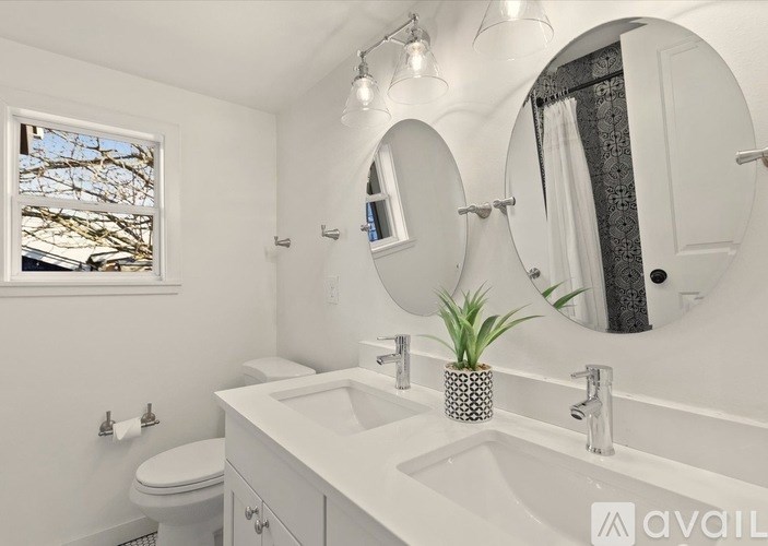 A bathroom with a white sink, toilet, and mirror.