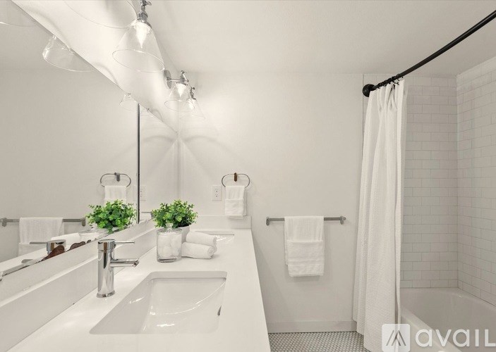 A white bathroom with a sink, mirror, and shower.