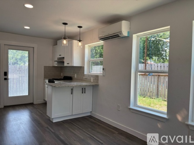 A kitchen with white cabinets and a marble countertop.