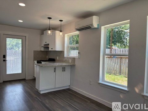 A kitchen with white cabinets and a marble countertop.