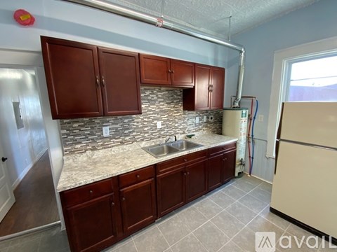 A kitchen with brown cabinets and a marble countertop.