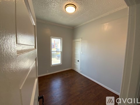 A room with a window and a door is available for rent.