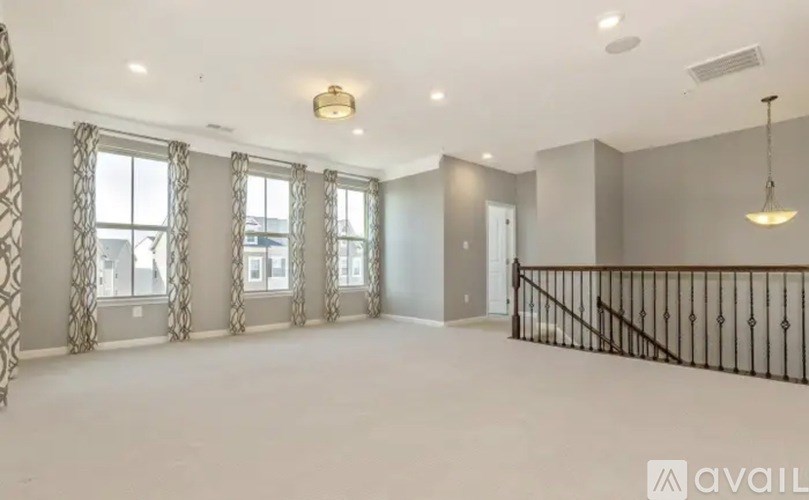 A spacious room with a balcony and large windows.