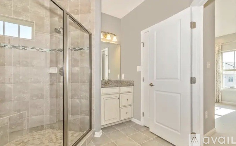 A bathroom with a walk-in shower and a white door.