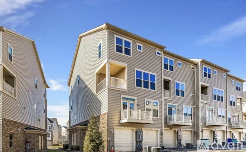 A row of modern apartment buildings with balconies and garages.