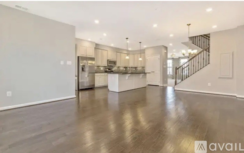A spacious kitchen with a staircase in the background.