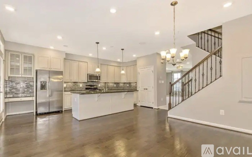 A spacious kitchen with a refrigerator, sink, and stove top.
