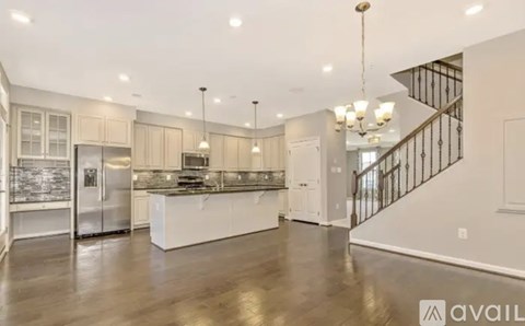 A spacious kitchen with a refrigerator, sink, and stove top.