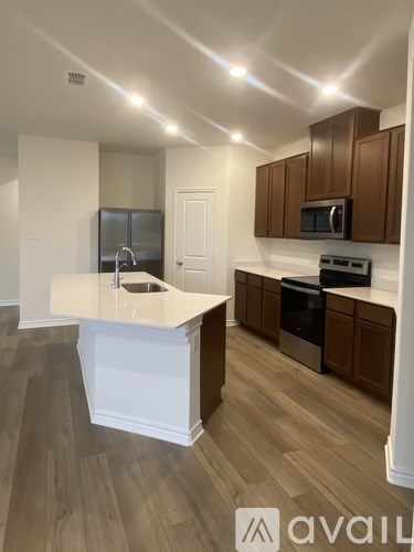 A kitchen with brown cabinets and a white island.