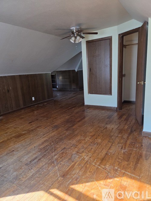 A room with wooden floors and a ceiling fan.