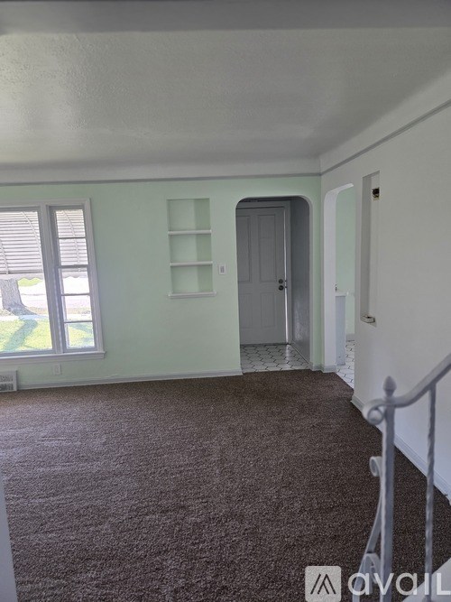 A room with a carpeted floor and a grey door.