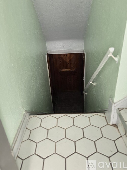 A bathroom with a white hexagonal tile floor and a white towel rack.