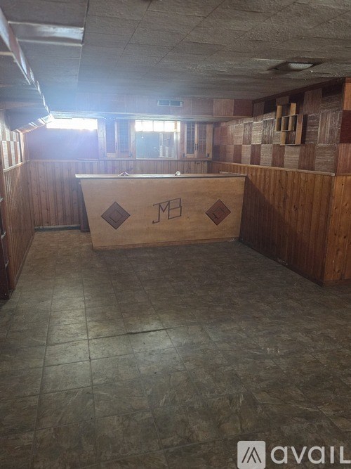 A room with wooden walls and a wooden table with the letters "ME" on it.
