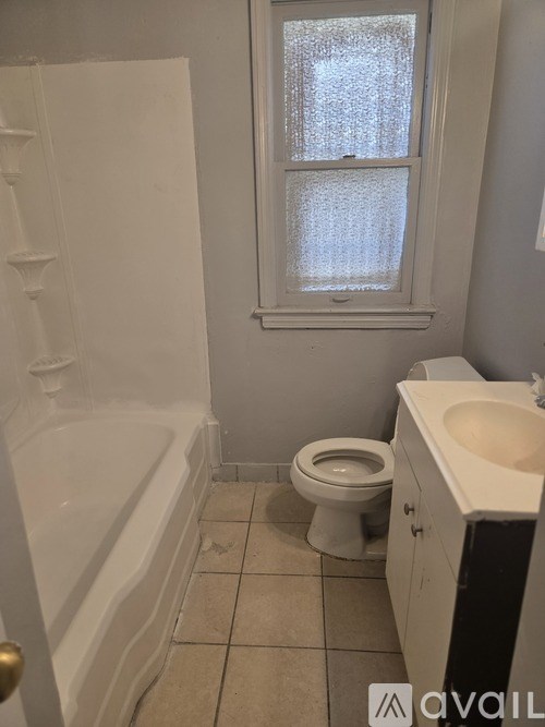 A bathroom with a toilet, sink, and bathtub.