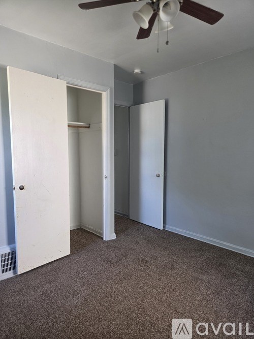 A room with a ceiling fan and two doors.