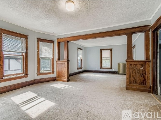 A spacious room with wooden trim and a carpeted floor.
