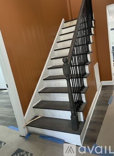 A staircase with a black railing and white steps.
