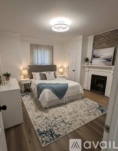 A bedroom with a large bed and a fireplace.