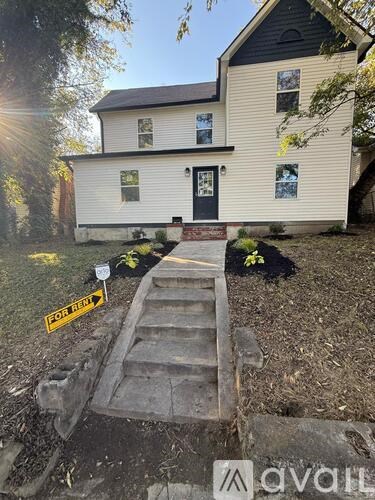 A house with a "For Sale" sign in front of it.