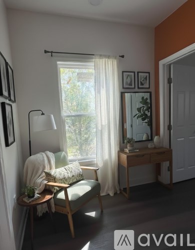 A living room with a chair, a table, and a window.