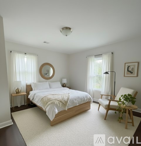 A bedroom with a bed, chair, and window.