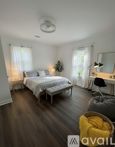 A bedroom with a bed, desk, and chair.