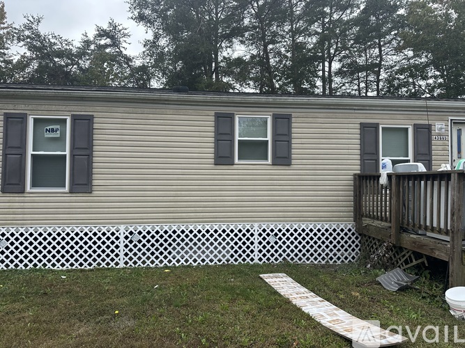 A mobile home with a white picket fence in front.