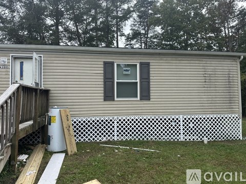 A mobile home with a white fence and a small porch.