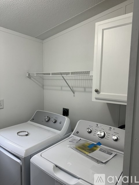 A mobile home with a deck and stairs leading to the door.