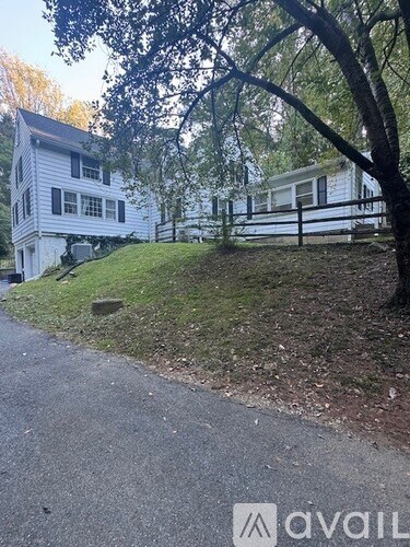A white house with a tree in front of it.