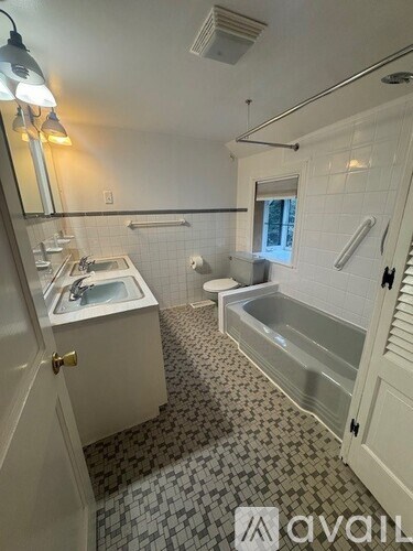 A bathroom with a white tub and sink.