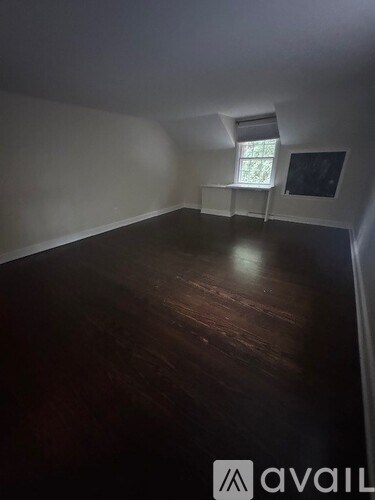 A room with wooden flooring and a window.