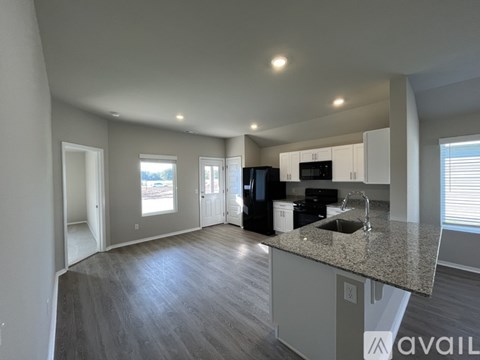 A kitchen with a granite countertop and a sink is shown.