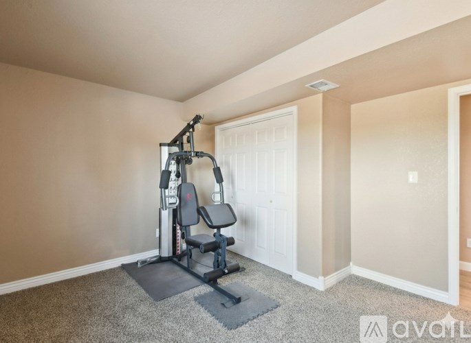 A home gym with a treadmill and weights.