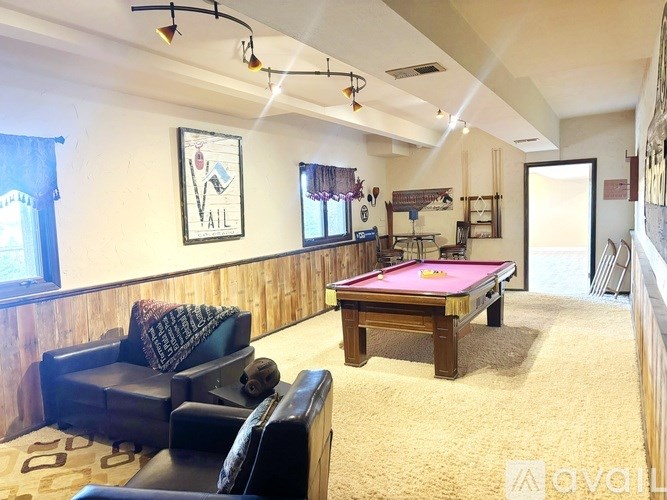 A room with a pool table and a couch.