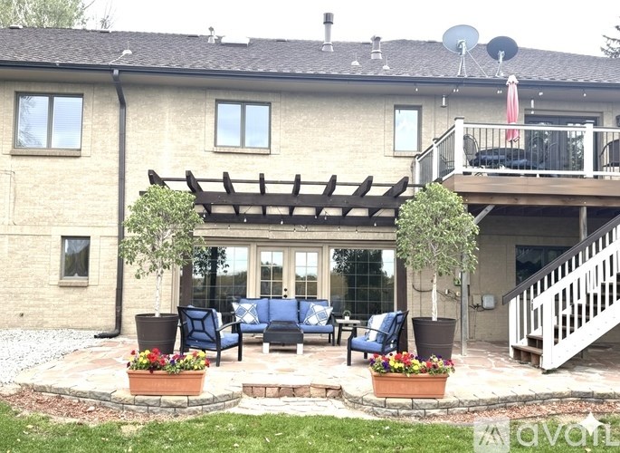 A patio with a couch, chairs, and a pergola.