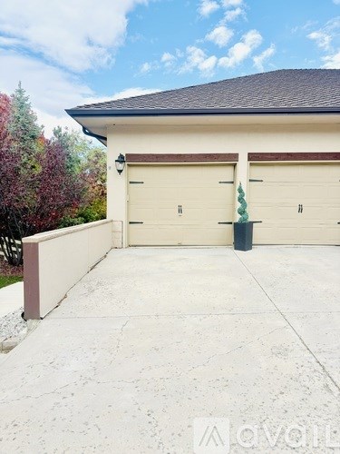 A house with a white garage door and a brown trim.
