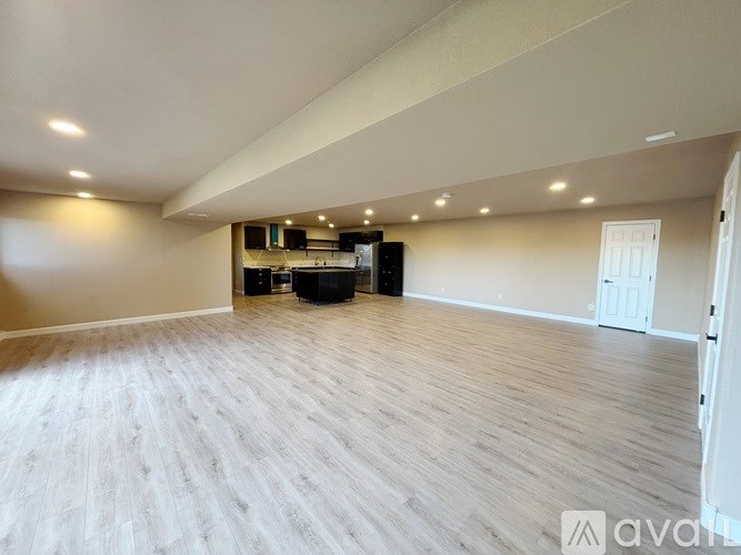 A spacious room with wooden flooring and a ceiling light fixture.
