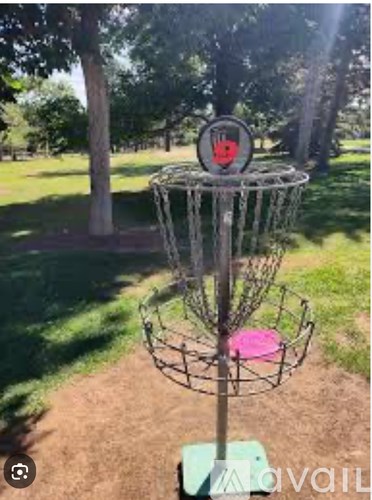 A disc golf basket with a red sign on it.