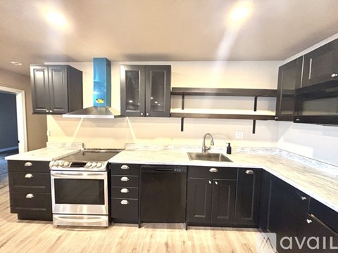 A kitchen with black cabinets and stainless steel appliances.