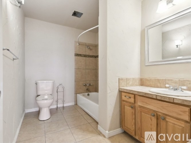 A bathroom with a white toilet, a bathtub, and a sink.